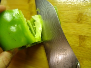 After you cut both the top & bottom ends of the pepper, slice the pepper diagonally to get into the pepper's inside, do not slice all the way through the pepper